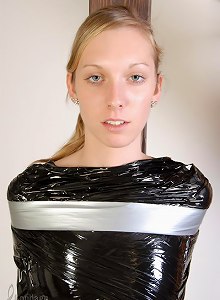 Young 18yo girl standing wrapped in plastic, taped to pole